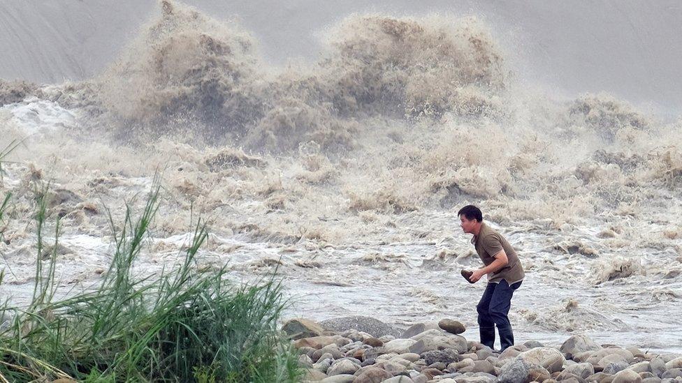 A local resident collects stones from the Xindian river after Typhoon Dujuan passed in the New Taipei City on September 29, 2015.