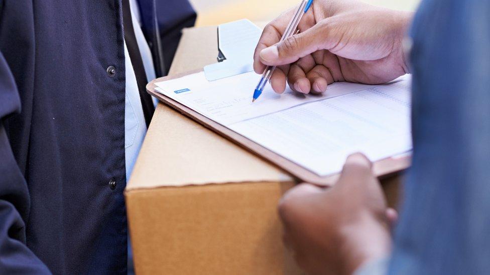 Close up of someone signing for a delivery