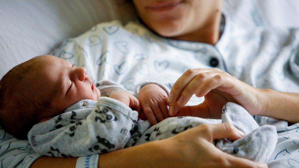 Newborn baby in his mother's arms