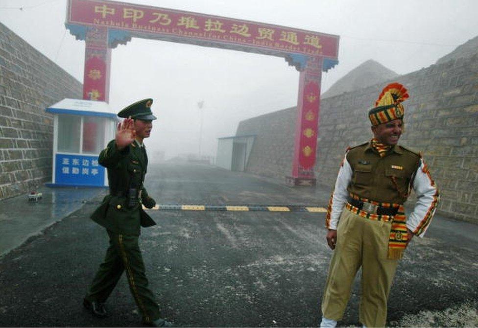 In this photograph taken on July 10, 2008 a Chinese soldier (L) and an Indian soldier stand guard at the Chinese side of the ancient Nathu La border crossing between India and China