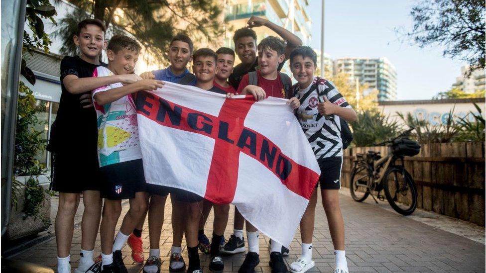 Children hold up an England flag