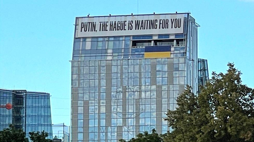 A banner on a building in central Vilnius, Lithuania, reads: "Putin, the Hague is waiting for you"