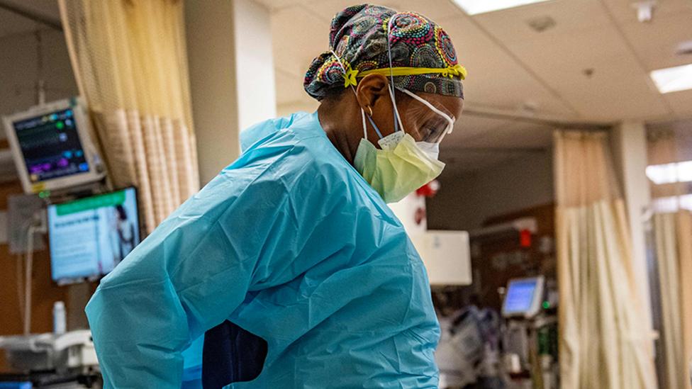 A medical workers puts on PPE before entering a negative pressure room at a US hospital