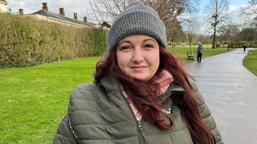 a white young woman wearing a hat in a park