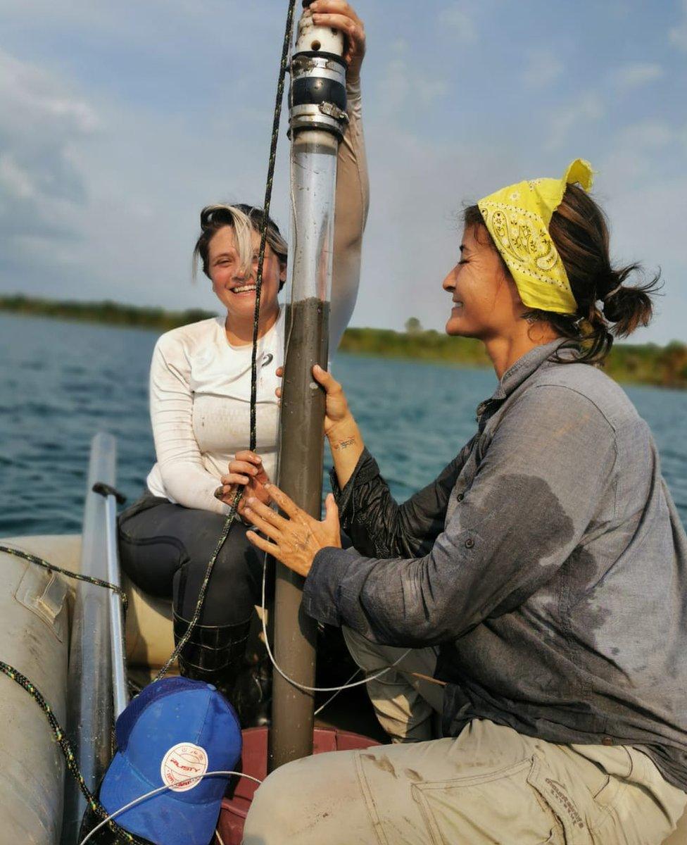 Scientists hold a mud core drilled from the shores of the Amazon river in Brazil