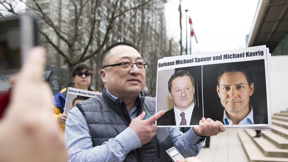 A China pro-democracy protester holds photos of Canadians Michael Spavor and Michael Kovrig