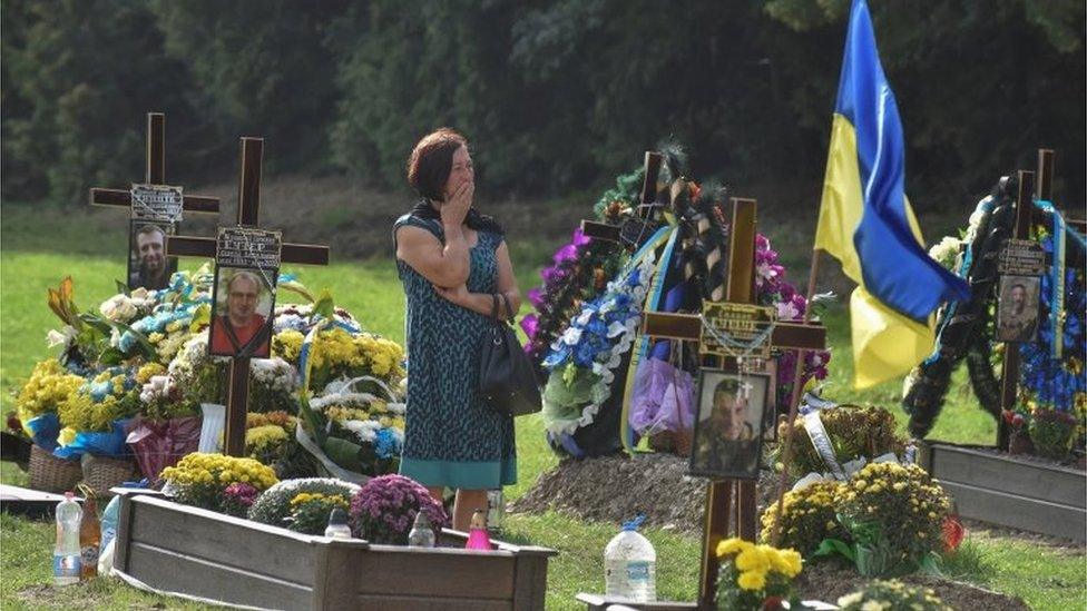 A woman reacts as she visits the tomb of her relative, a Ukrainian serviceman who was killed in a fight against Russian troops, amid Russia's attack on Ukraine, during the Independence Day in Lviv, Ukraine August 24, 2022.