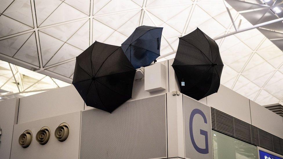 Umbrellas block CCTV cameras as anti-government protesters attend a demonstration