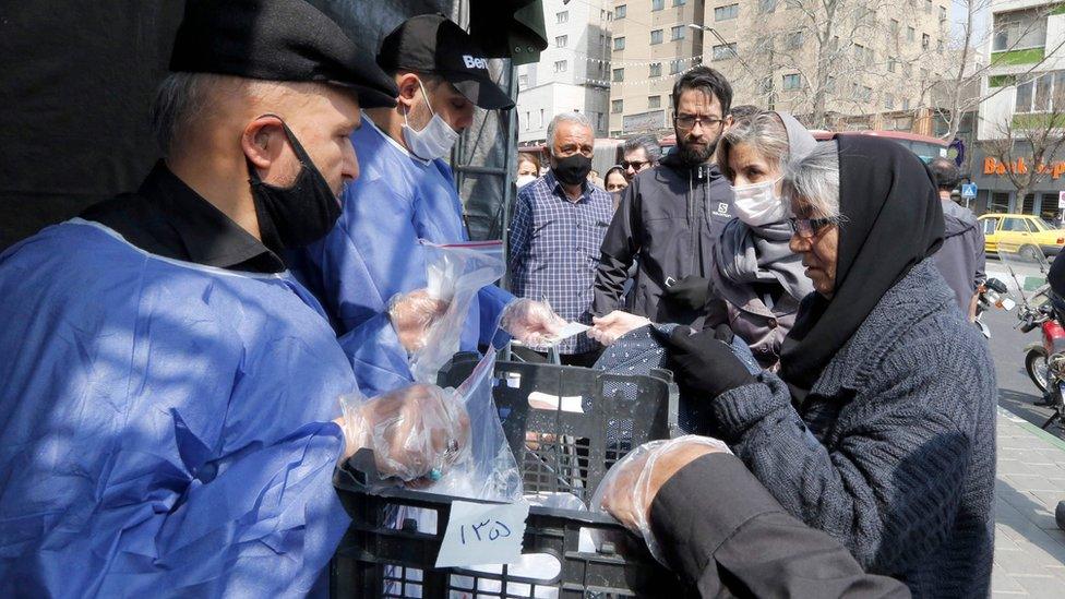 People queue to receive packages of precautions against Covid-19 from the paramilitary Basij force in Tehran, Iran (15 March 2020)