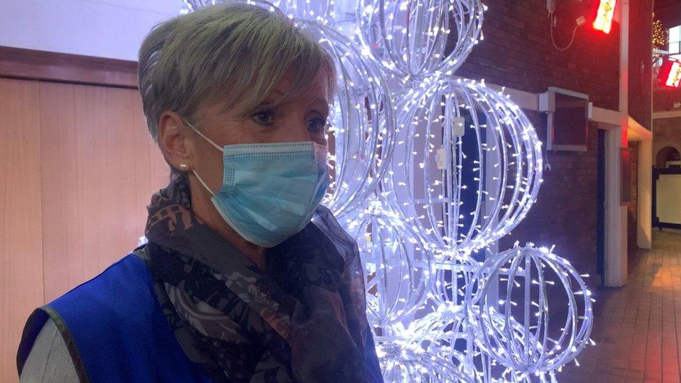 A lady standing in front of a glowing christmas tree