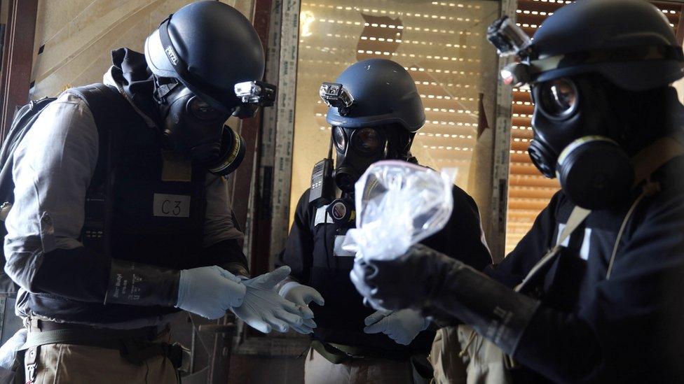 UN chemical weapons expert holds a plastic bag containing samples from one of the sites of a chemical weapons attack in the Ain Tarma area of Damascus (29 August 2013)