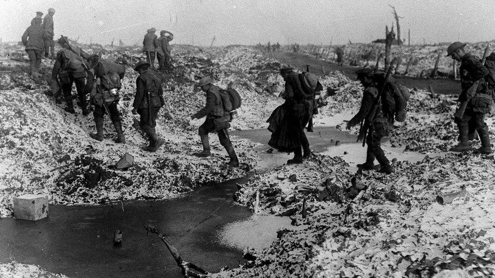 British soldiers negotiating a shell-cratered, Winter landscape along the River Somme