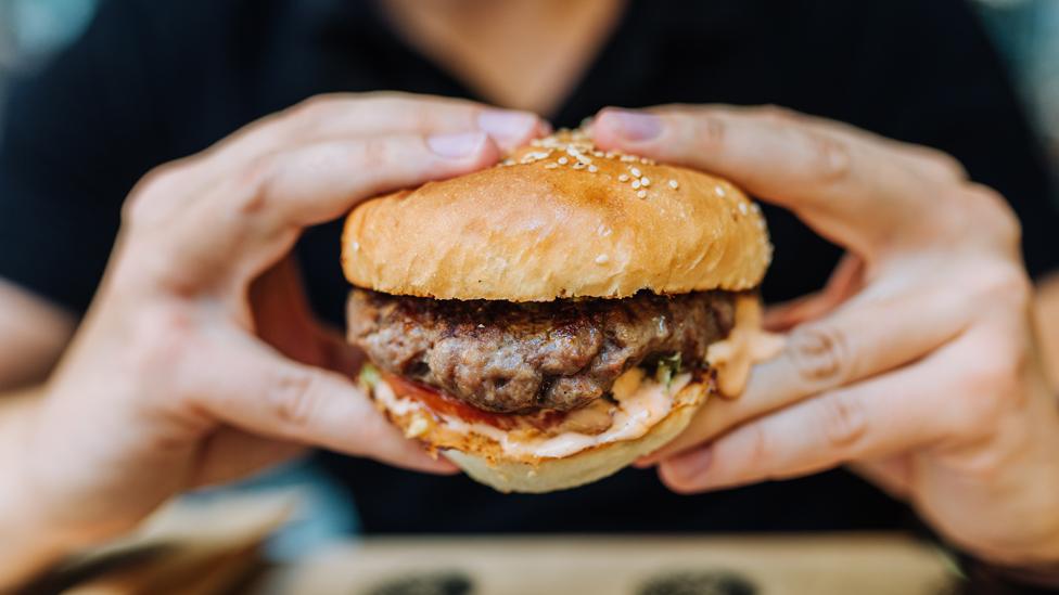 Eating tasty hamburger.