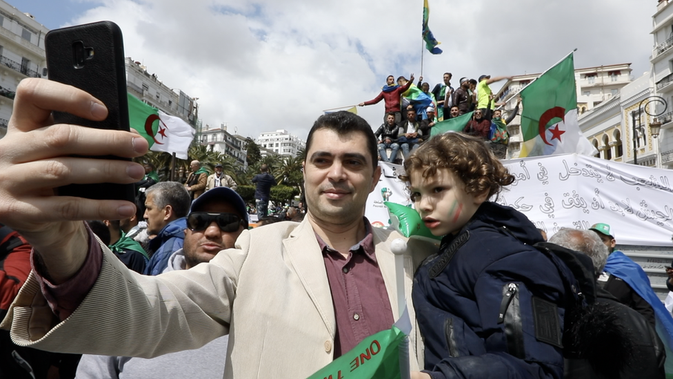 A man and a child protest outside Le Grande Poste in Algiers