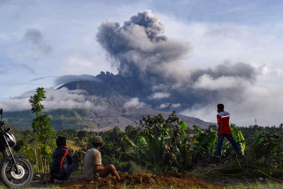 Villagers watch the eruption of Mount Sinabung