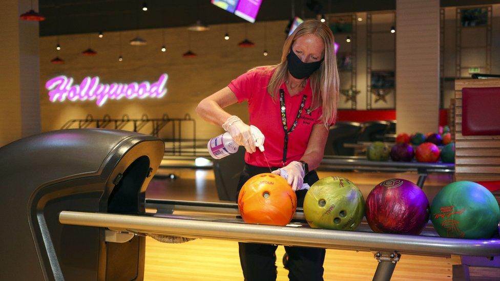 A woman sprays a bowling ball at Hollywood Bowl