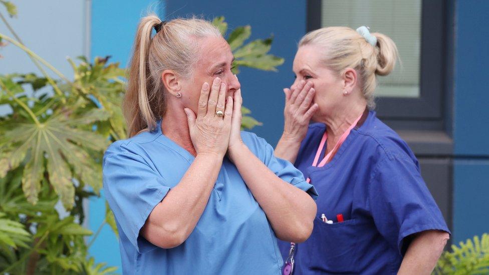 Staff react outside Salford Royal Hospital in Manchester during a minute"s silence to pay tribute to the NHS staff and key workers who have died during the coronavirus outbreak.