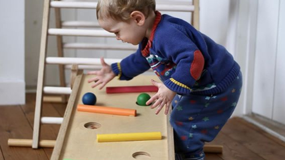 Child playing with wooden toys