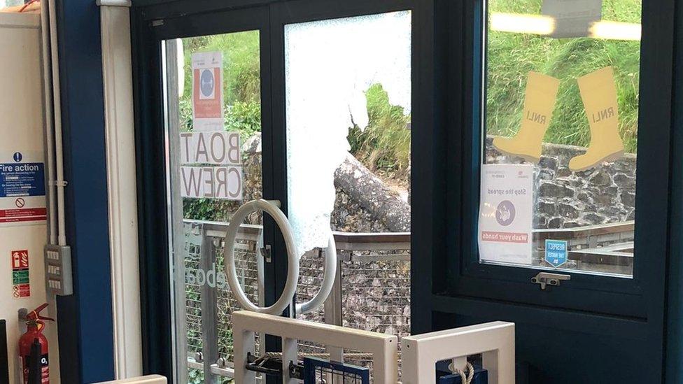 Smashed glass door at RNLI shop in Tenby