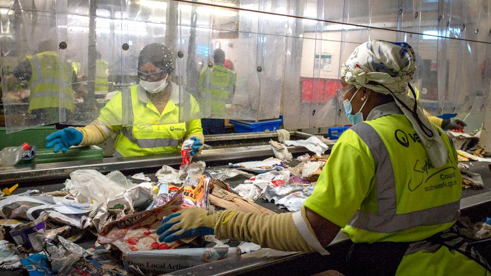 Two women sorting through recycling