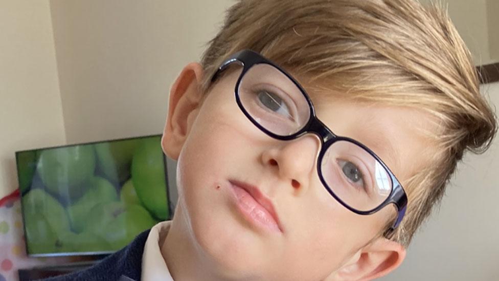 William wearing glasses with his head tilted to the right