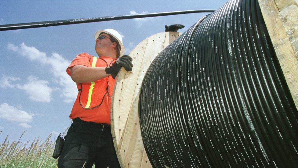 A workman laying fibre optic cable