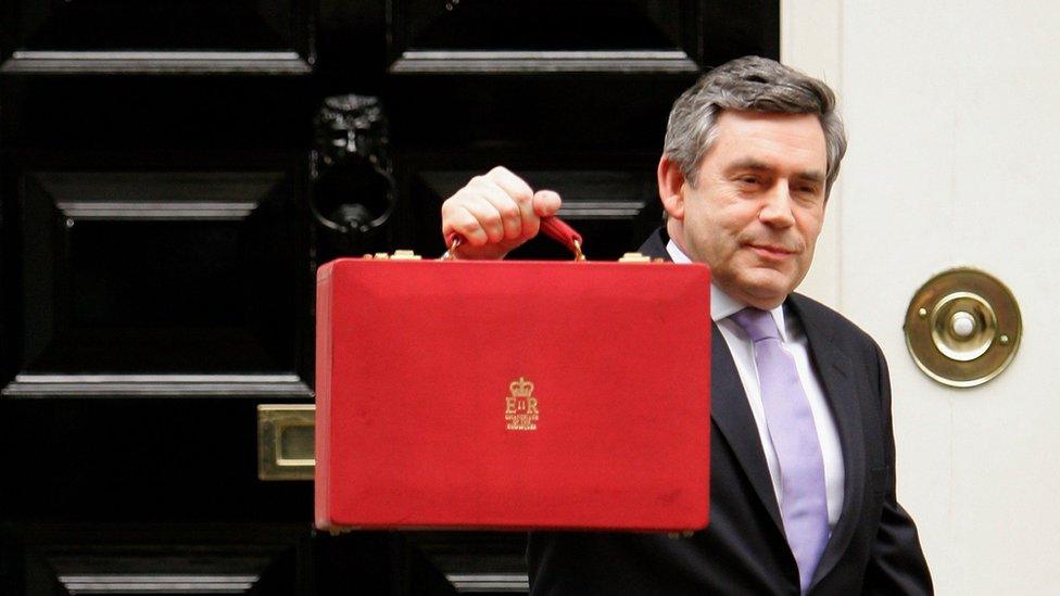 Britain's Chancellor of the Exchequer Gordon Brown holds a brief case holding the annual budget as he leaves No 11 (Number Eleven) Downing Street on March 22, 2006 in London England.