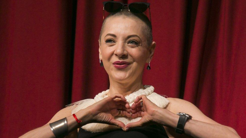 Mexican actress Edith Gonzalez at a press conference to announce a play in 2017, making a heart with a hands