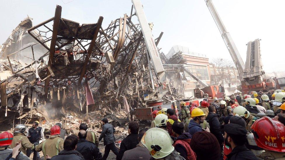 Rescue workers gather in front of the collapsed Plasco building in Tehran, Iran (19 January 2017)