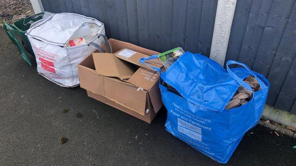 A white and blue reusable bag and a cardboard box in the middle.