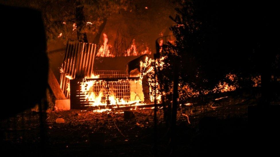 A house falls apart as flames rip through it