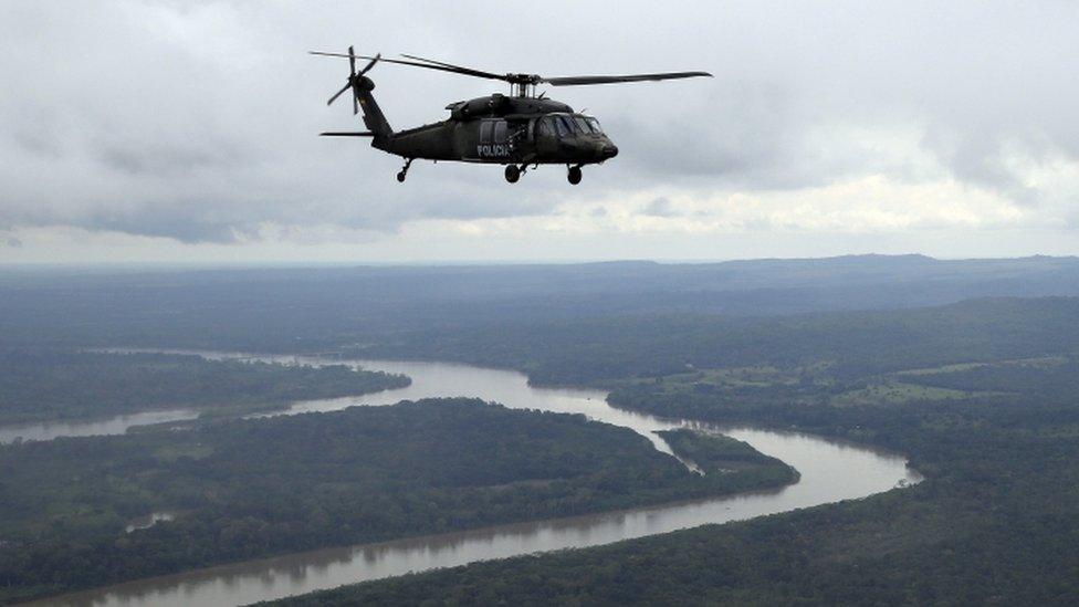 A anti-drug helicopter flies over San Jose del Guaviare, Colombia, Tuesday, Aug. 2, 2016.