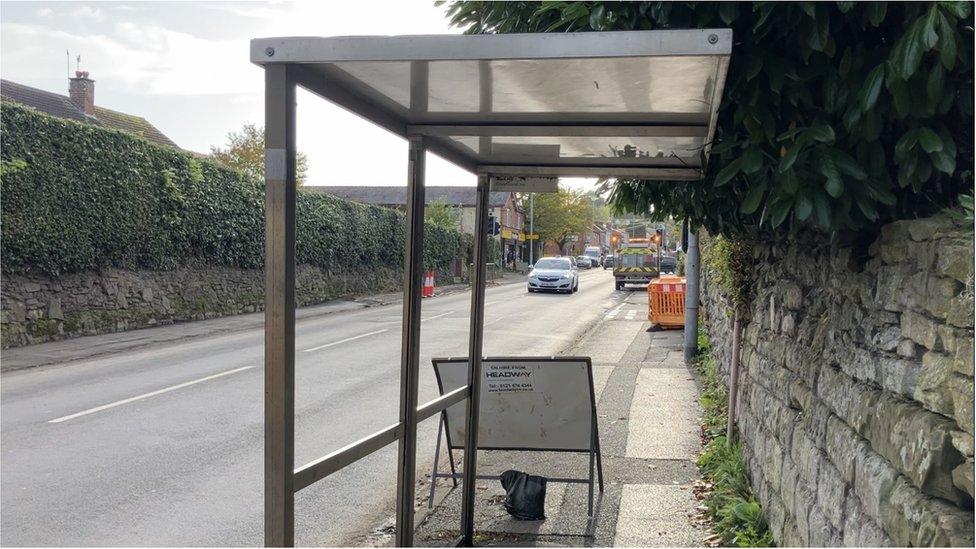 The bus shelter on Worcester Road, Bromsgrove, missing glass panels