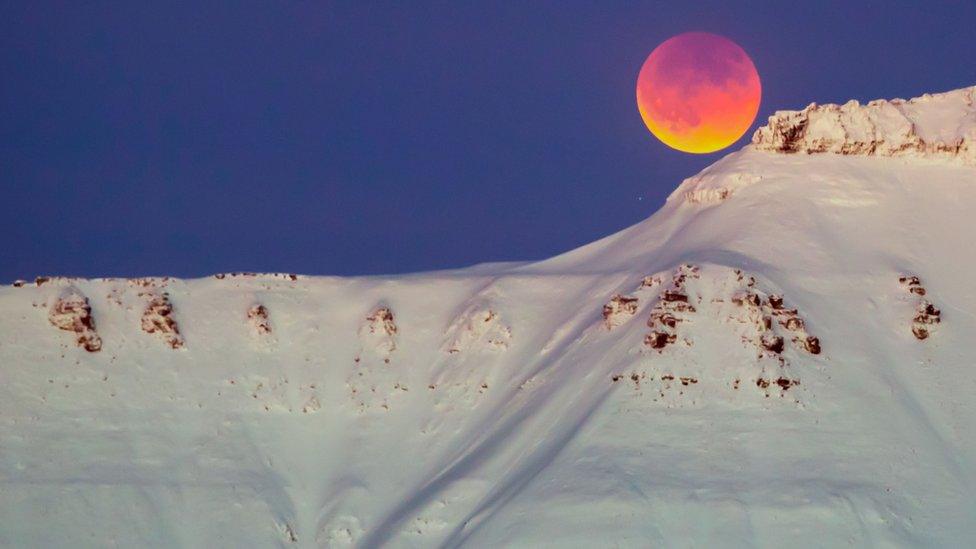 Moon behind mountain