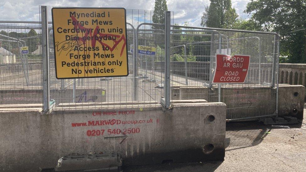 The bridge blocked off with signage, gates and concrete blocks