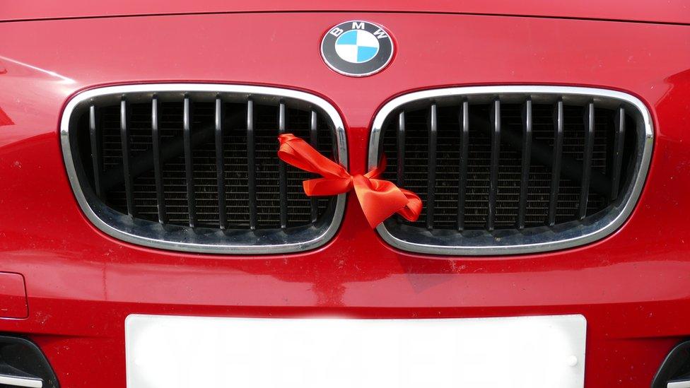 Red BMW with a red ribbon to show the driver disagrees with the 20mph zones.