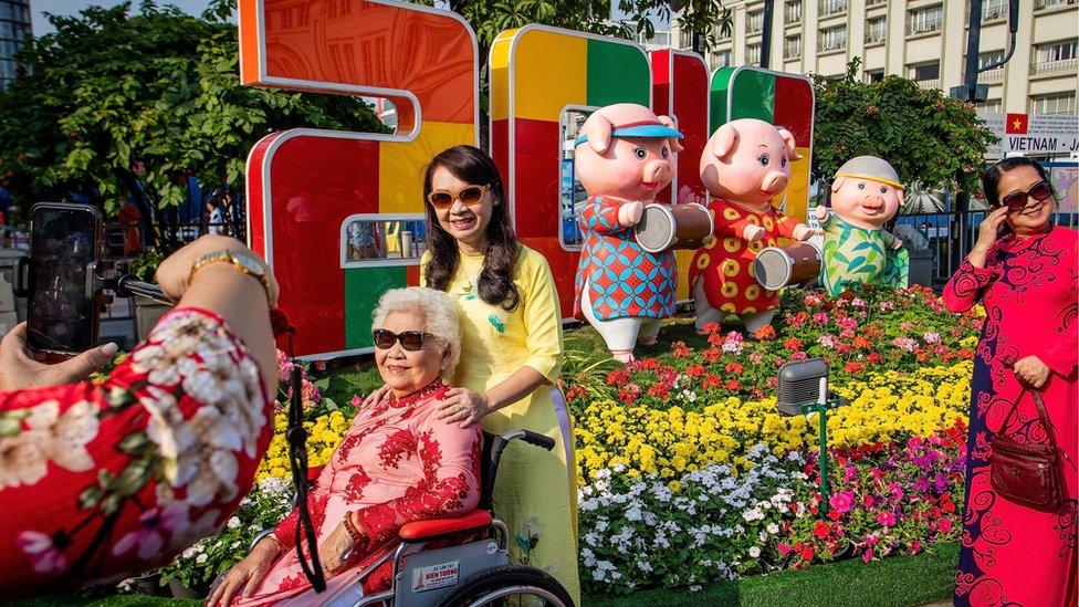 Vietnamese taking pictures in front of New Year sign