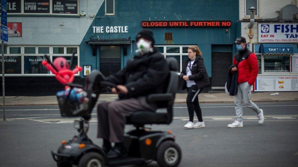 People walk past a closed pub in Blackpool town centre on 17 October 2020