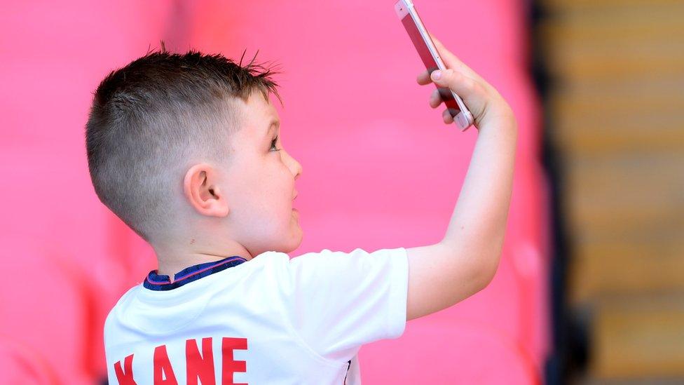 A young England fan is seen inside the stadium before the match