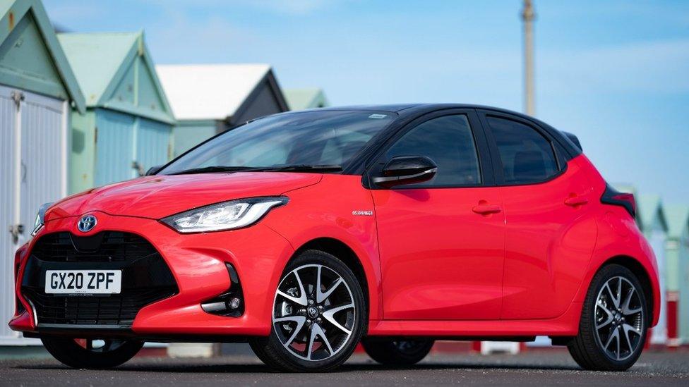 A Toyota Yaris posing with some beach huts