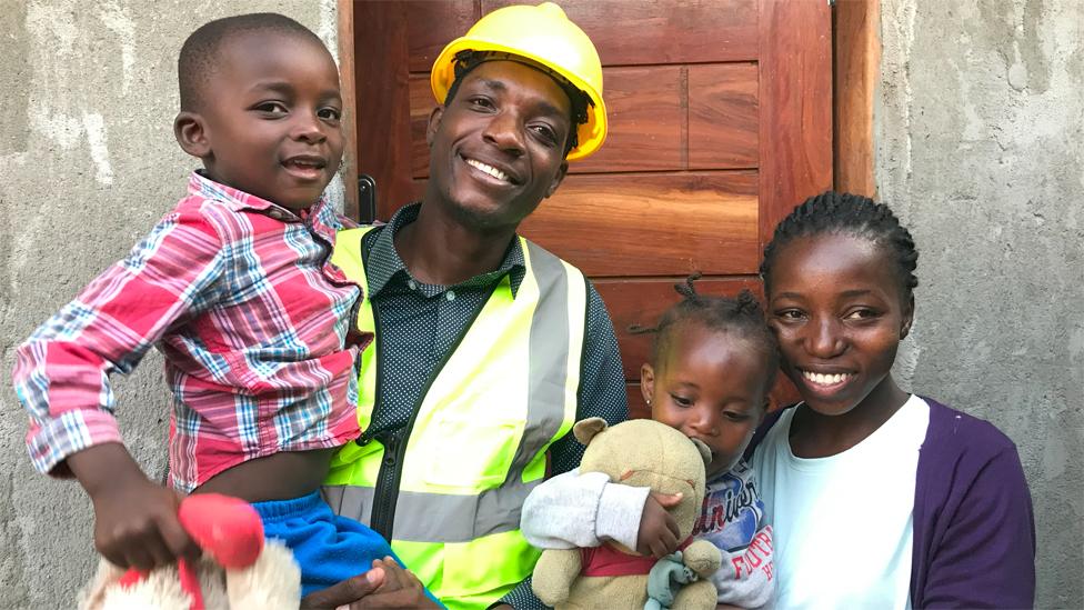 José Joaquim and his family outside the new house he is building