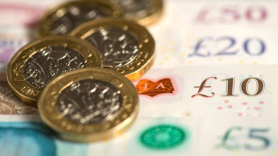 An artistic shot of pound coins and a series of Bank of England notes