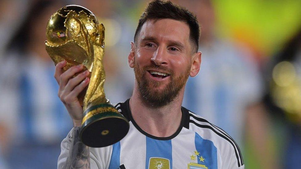 Lionel Messi holds up the World Cup trophy