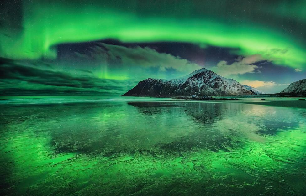 A vivid aurora over Skagsanden beach, Lofoten Islands, Norway.