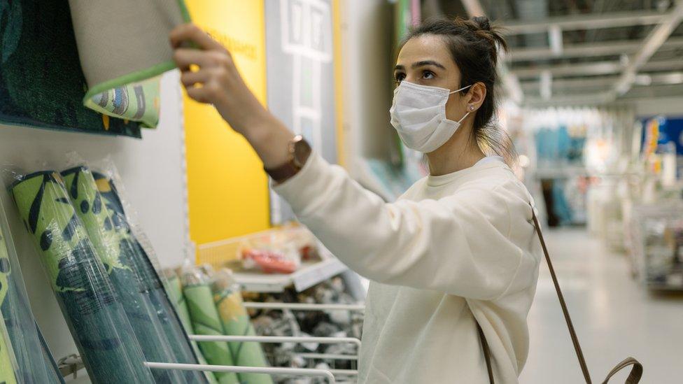 Woman wearing face mask in a furniture shop