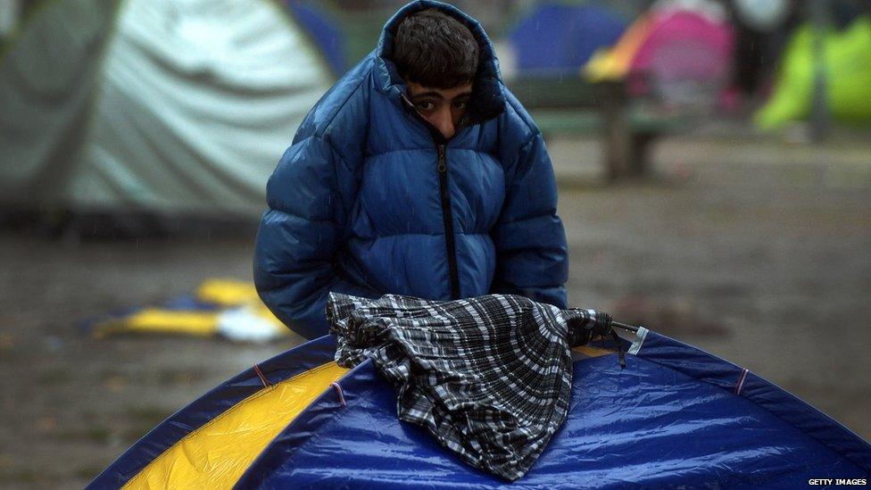 Boy shelters from rain in Belgrade park