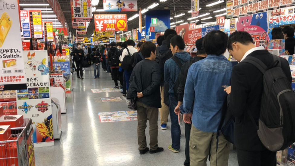 a lot of people in a queue inside the store