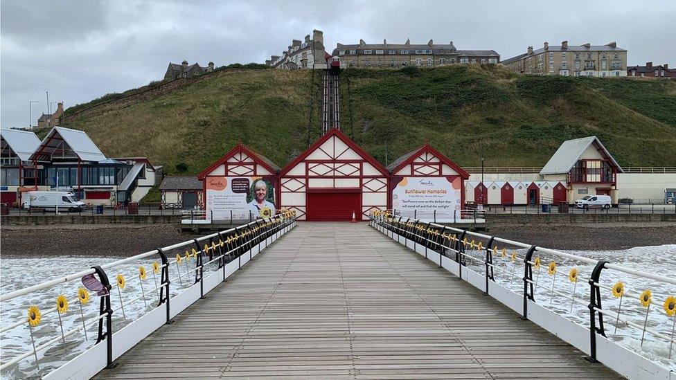 Saltburn Pier with the sunflowers attached to railings