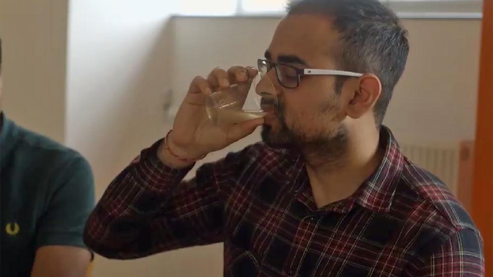 Volunteer drinking apple cider vinegar