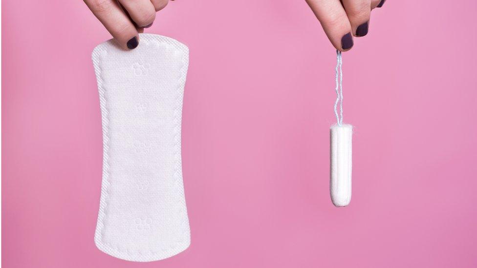 Women's hands holding sanitary products